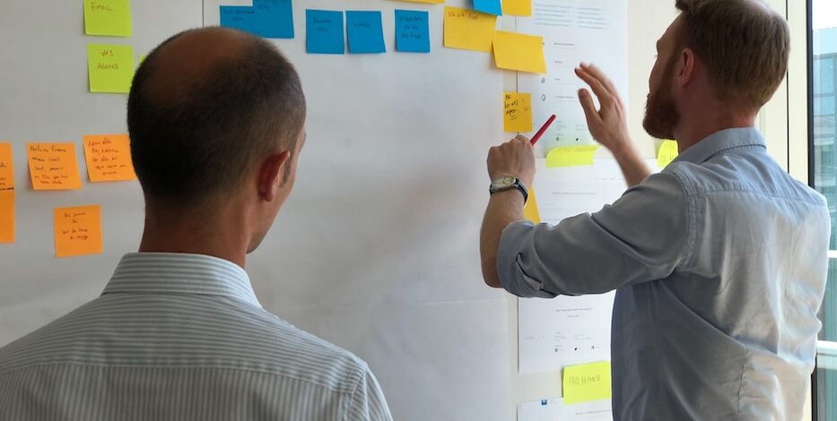 man in gray shirt facing sticky notes