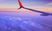 person in a plane flying at high altitude taking photo of left airplane wing during daytime